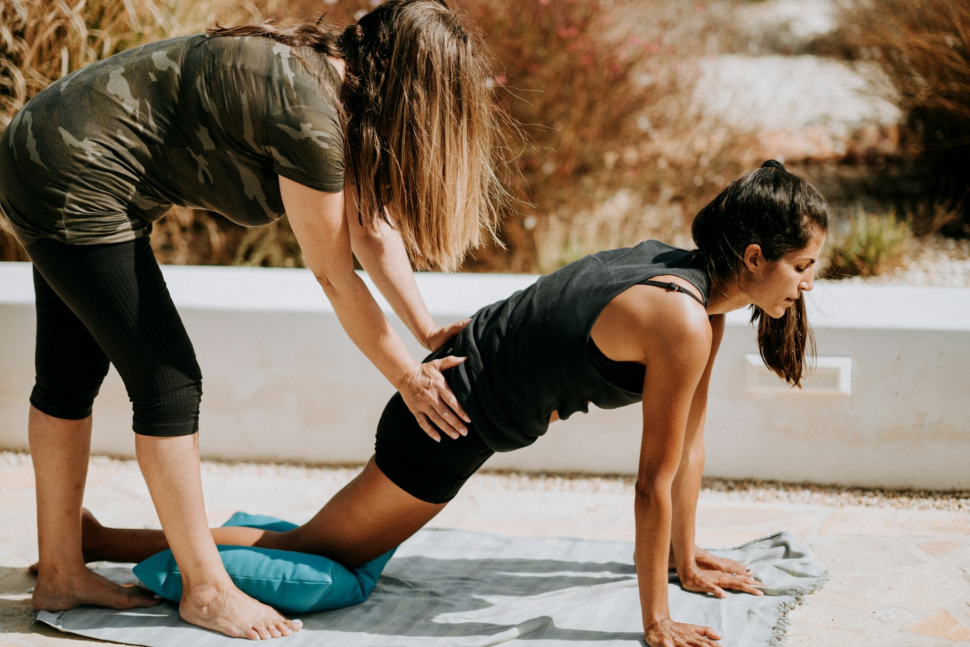 woman in black tank top and black shorts kneeling on mat